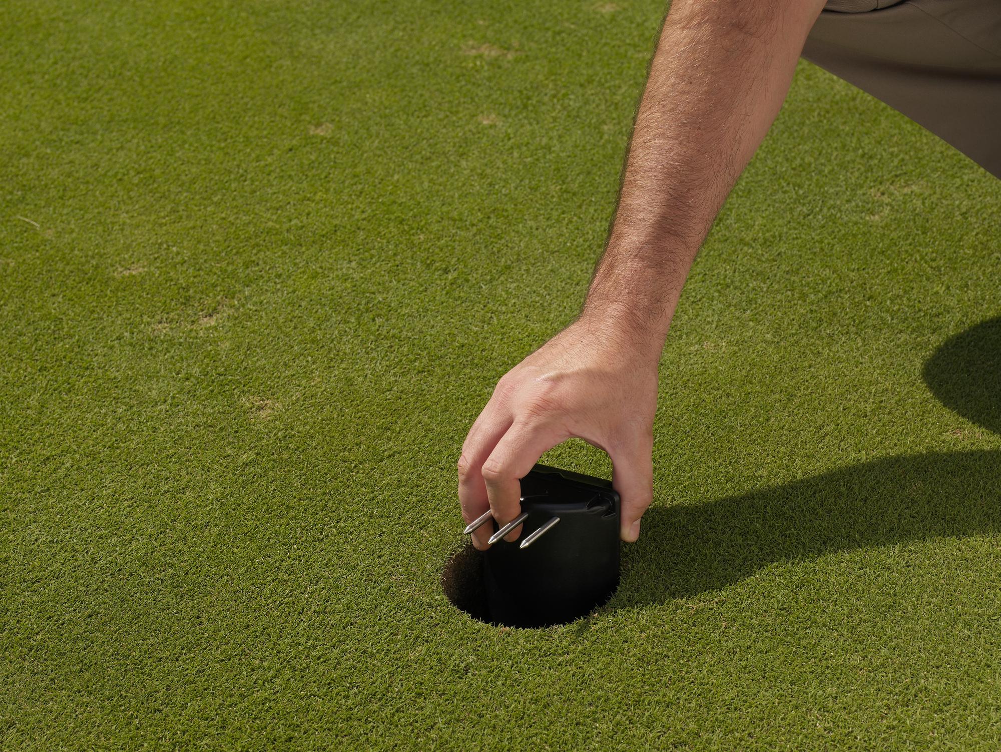 A Toro soil moisture detector being taken out of the hole.